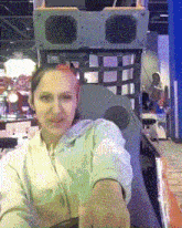 a woman with pink hair is sitting in a chair with a speaker in the background