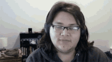 a woman wearing glasses and headphones is looking at the camera