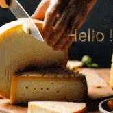 a person is cutting a piece of cheese with the word hello written in the background