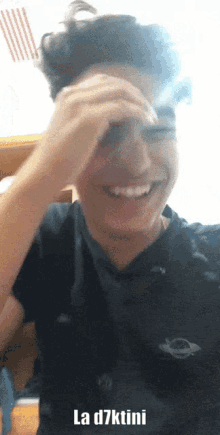 a young man covering his face with his hand and the words " la d7ktini " above him