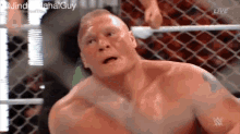 a man without a shirt is standing in a wrestling ring and making a face .