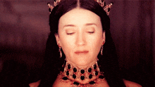 a woman with her eyes closed wearing a tiara and a choker