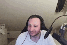 a man wearing headphones and a microphone is sitting in front of a camera .