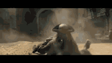 a man in a pirate hat is laying on the ground in a dirt field .