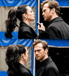 a man and a woman are looking at each other in front of a blue tent