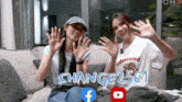 two women are sitting on a couch with their hands up and the words change2561 on the bottom .
