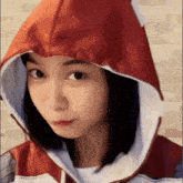 a close up of a woman wearing a red hoodie