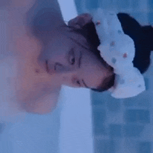 a woman is taking a bath in a bathtub and wearing a headband .