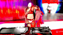 a woman in a bikini is standing in front of a sign that says " live "