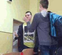a man wearing a shirt that says " wow " is standing next to another man