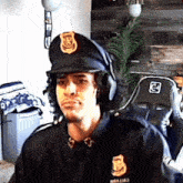 a man in a police uniform is wearing headphones and a hat that has the letter d on it