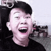 a young man is making a funny face with his mouth open in a room .