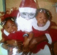 two little girls are posing for a picture with a santa claus statue
