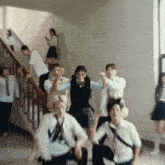a group of students are dancing in a hallway with stairs in the background