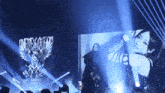 a woman stands on a stage in front of a screen that says death & flight