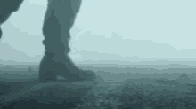 a person is walking on a foggy road in the fog .