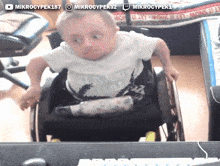 a young boy in a wheelchair is wearing a shirt that says ' his summer time '