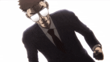 a man in a suit and tie with glasses on looks at the camera