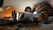 a man wearing headphones is reading a pamphlet that says panatec on it