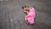 a woman wearing a pink hoodie and neon green shorts laying on the ground