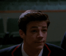 a close up of a man 's face with a suit and tie