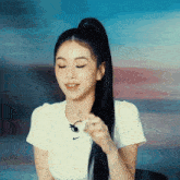 a woman wearing a white nike t-shirt holds something in her hand