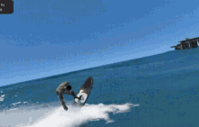 a man is riding a wave on a surfboard with the letter g on the front