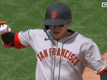 a baseball player wearing a san francisco jersey holds a baseball