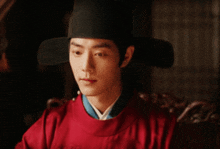 a man wearing a hat and a red shirt