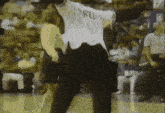 a man in a white shirt with the word rld on it stands on a basketball court .