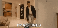 a man is kneeling down in a living room and saying `` i 'm mastered '' while cleaning the floor .