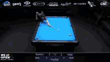 a pool table with a blue cloth and two men playing