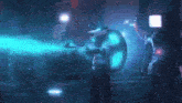 a man in a cowboy hat is standing in a dark room with a blue light coming from behind him .