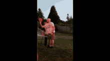 a group of people are playing a game of frisbee in a backyard .