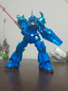 a blue robot with a shield and a light saber