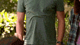 a man in a green shirt is standing next to a woman
