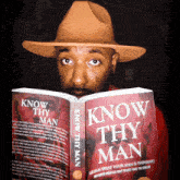 a man wearing a hat is reading a book called know thy man