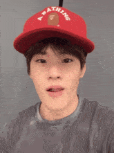 a young man wearing a red hat that says bathing ape