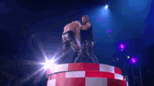 two wrestlers are standing on top of a red and white checkered circle