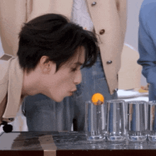 a man drinking from a glass with a ball in it