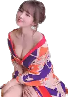 a woman in a colorful kimono is sitting on the floor .