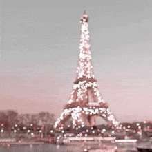 the eiffel tower is lit up with pink lights