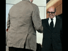 a man wearing sunglasses shakes hands with another man