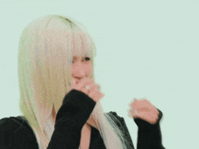 a woman with long blonde hair is wearing a black sweater and a black hat .