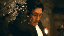 a man in a suit and glasses holds a sword