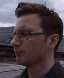 a close up of a man wearing glasses and a black jacket