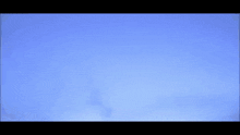 a plane is flying through a cloudy sky with the tail visible