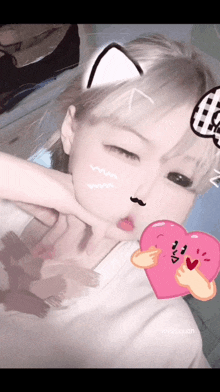 a girl with a cat ear and a mustache is holding a pink heart in front of her face