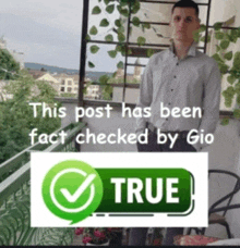 a man is standing on a balcony next to a true sign