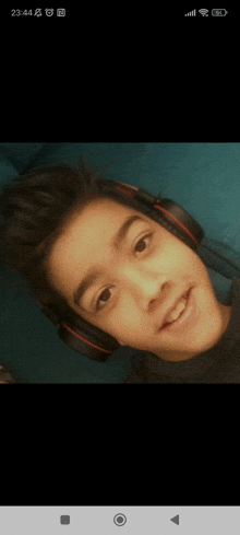 a young boy wearing headphones looks at the camera and smiles